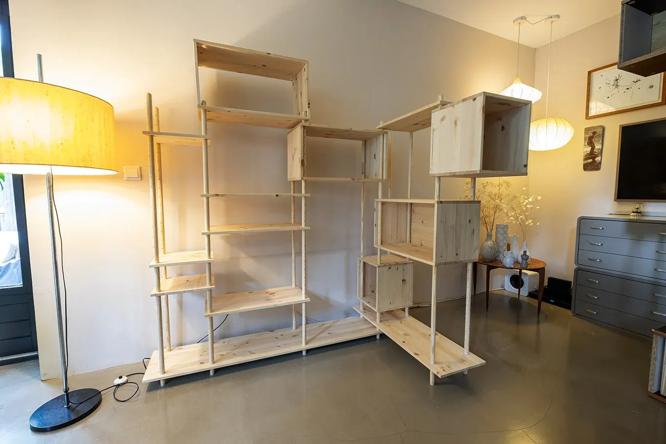 Two Regenerative Modular Cabinets set up as open shelving against a wall, still empty, beside a floor lamp